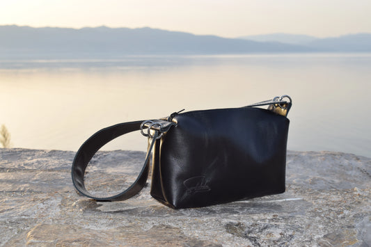 Elegant wide-strap handbag in premium black Italian goat leather, featuring four silver O-rings, connecting O-ring, black zipper closure, and meticulous black stitching — timeless luxury by Santebela.