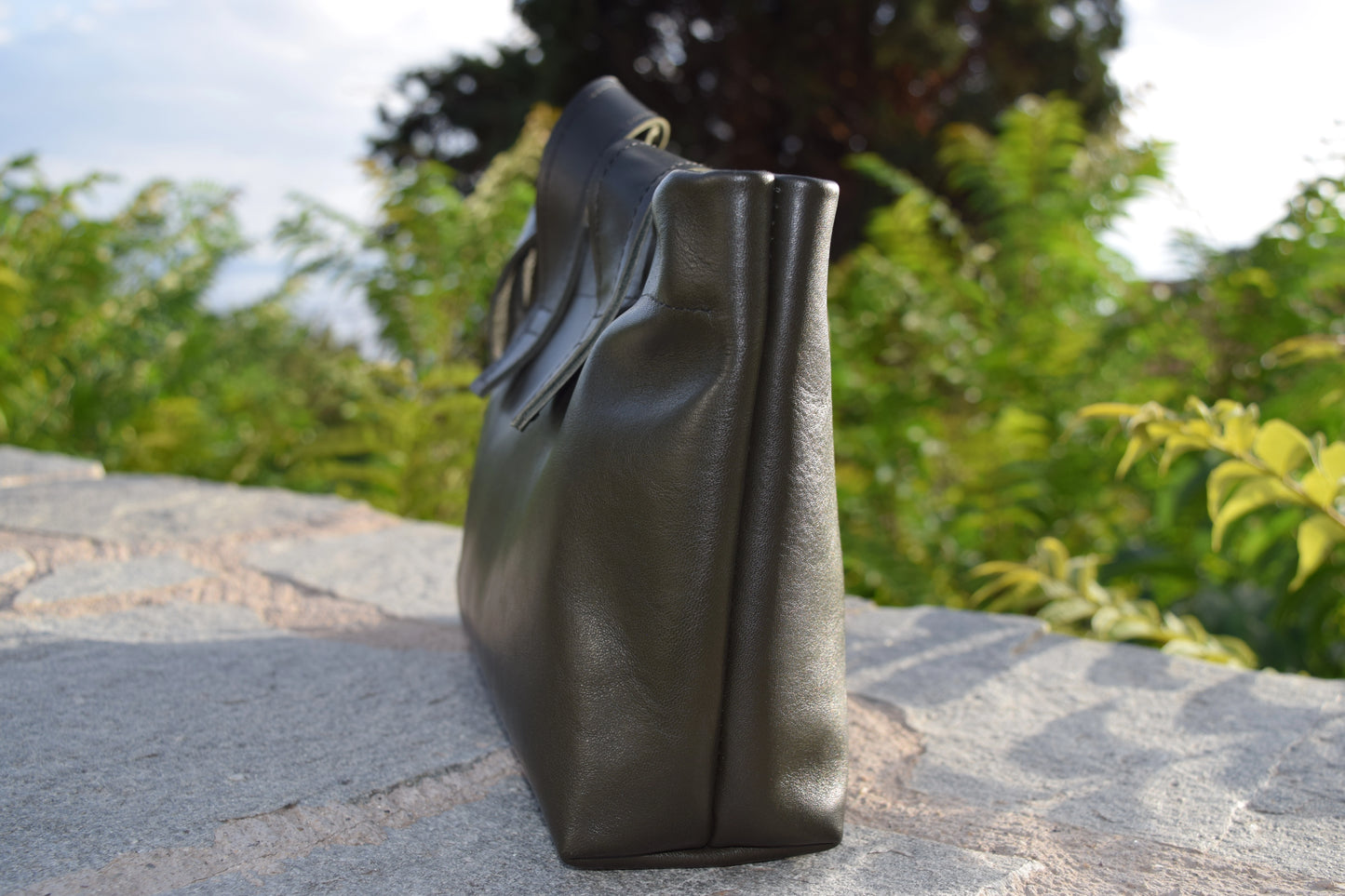 Side profile of the Dark Green Olive Leather Tote Bag, highlighting structured silhouette and precise black stitching by Santebela