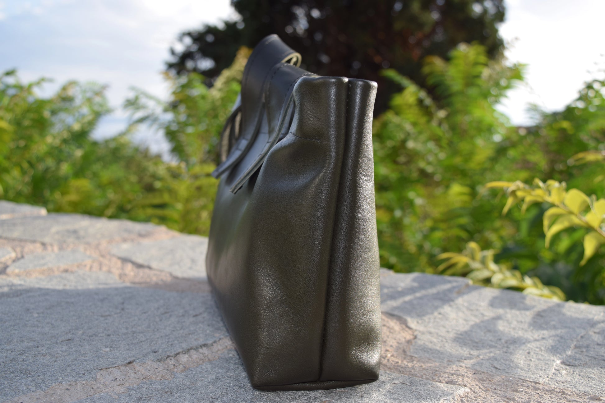 Side profile of the Dark Green Olive Leather Tote Bag, highlighting structured silhouette and precise black stitching by Santebela