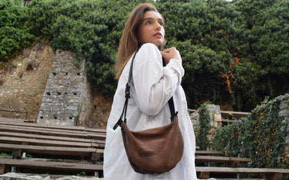 Minimalistic luxury crossbody brown bag presented by the model on the stairs from the workshop to you by Santebela