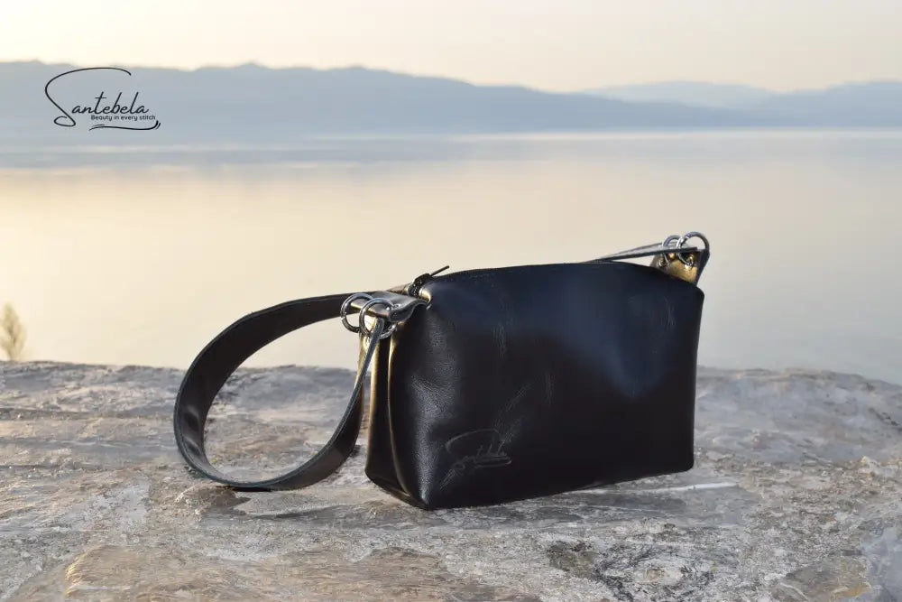 Elegant wide-strap handbag in premium black Italian goat leather, featuring four silver O-rings, connecting O-ring, black zipper closure, and meticulous black stitching — timeless luxury by Santebela.